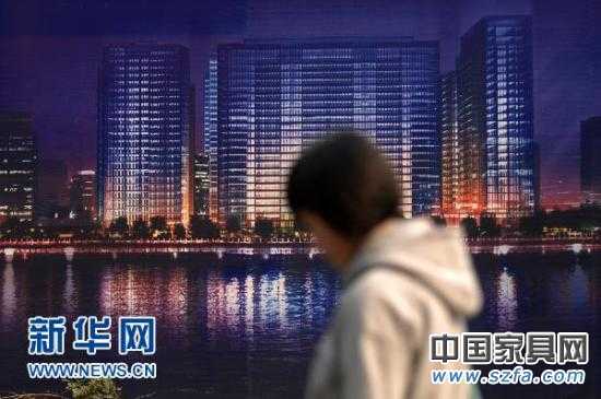 一位市民從杭州市區(qū)的一處商業(yè)樓盤廣告牌前走過（2010年11月4日攝）。新華社記者 黃宗治 攝 